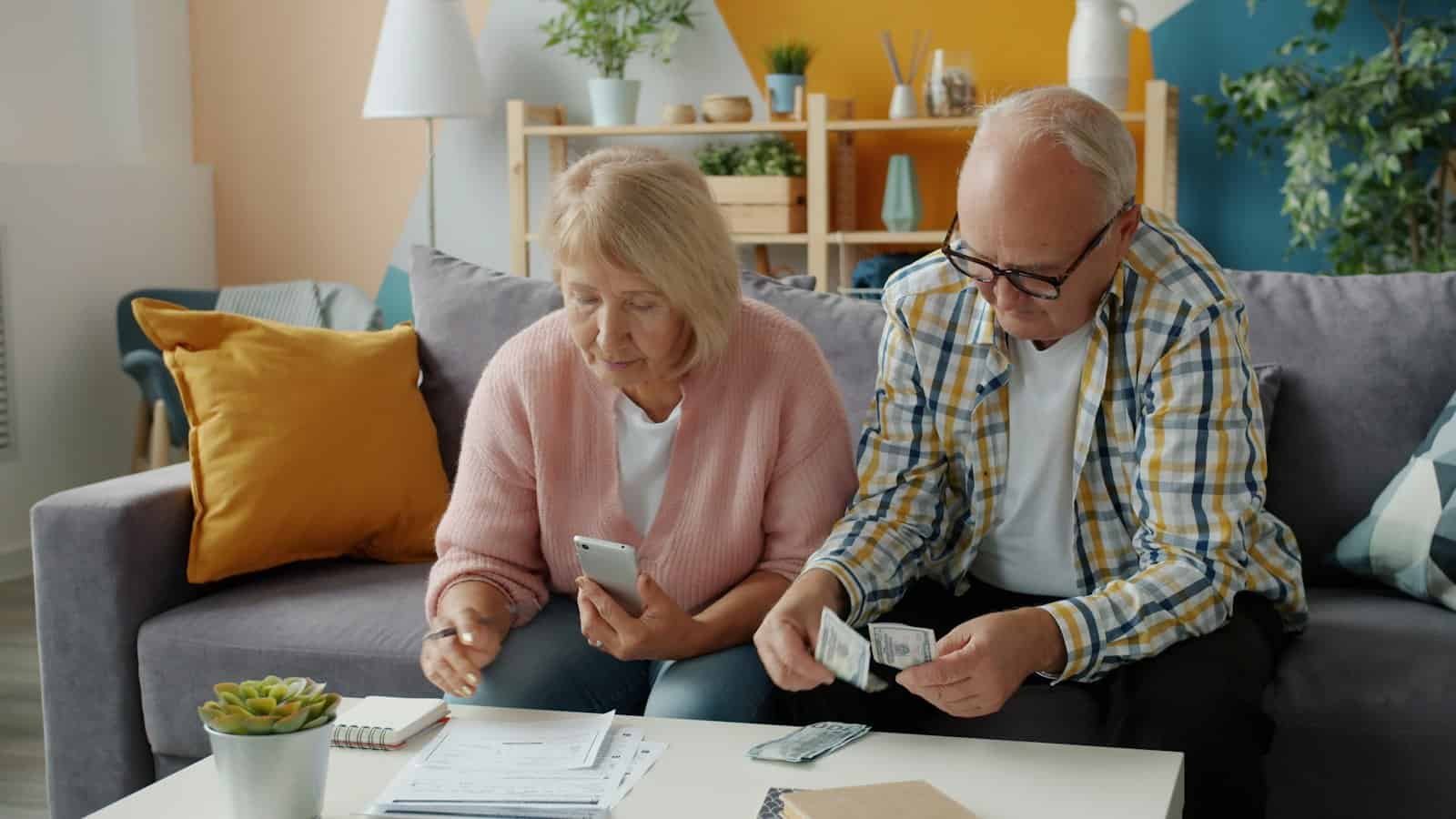 An older couple sitting together at home going over financial papers and statements.