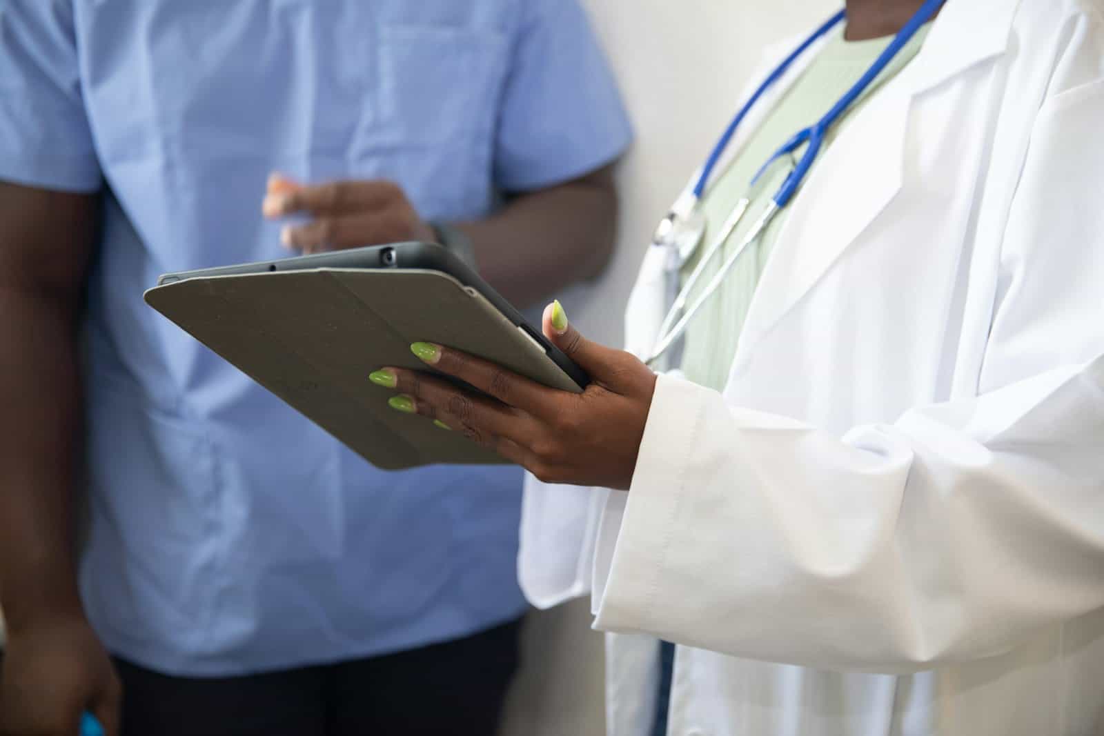 A doctor shows a patient information on a tablet during a checkup.
